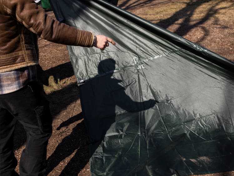 Course participants learn how to set up a temporary emergency shelter with a tarpaulin.
