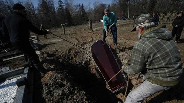 Kiew: Ein Sarg wird in ein Grab eingelassen am 25. März 2022.