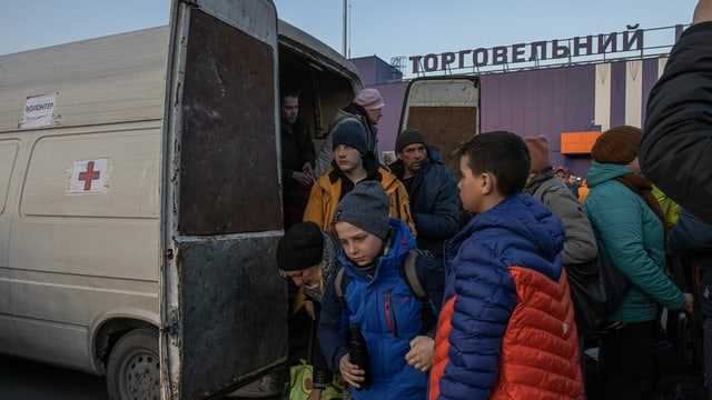  Menschen steigen nach ihrer Ankunft am Evakuierungspunkt in Saporischschja aus einem Minivan aus 