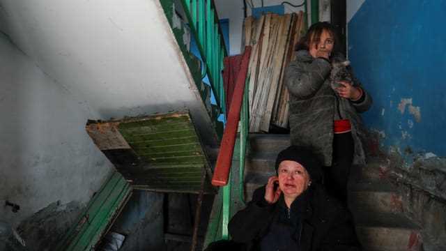 Bewohnerin mit ihrer Enkeltochter in einem Wohnhaus in Mariupol, aufgenommen am 25. März 2022. 