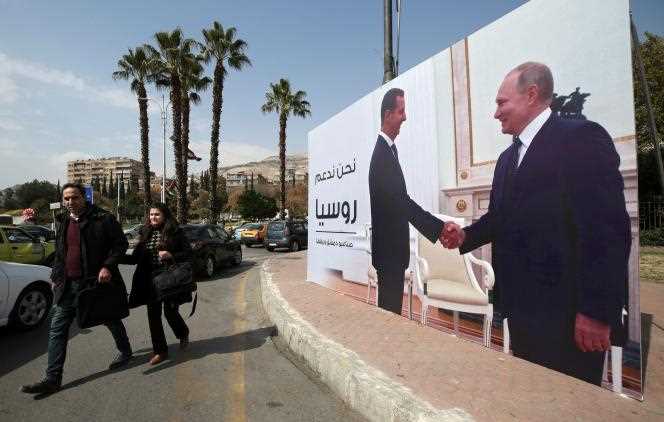 In Damascus, Syria, a poster shows President Bashar Al-Assad and President Vladimir Putin shaking hands.  March 7, 2022.