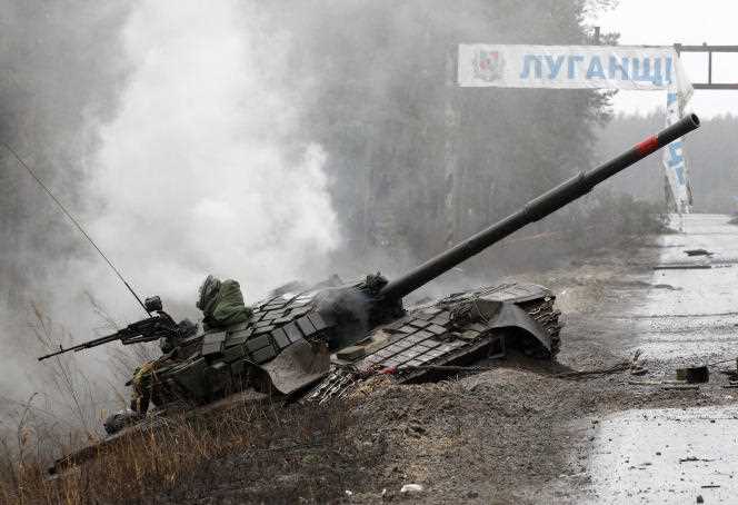 Smoke rises from a Russian tank destroyed by Ukrainian forces on the side of a road in Luhansk Oblast on February 26, 2022.