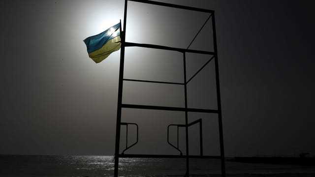 Ukrainische Fahne bei Nachtdämmerung vor Strand in Odessa