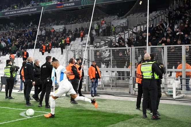 Marseille's Dimitri Payet takes a corner under the protection of the security forces, in front of the Greek supporters' stand, on April 7, 2022, at the Vélodrome stadium.