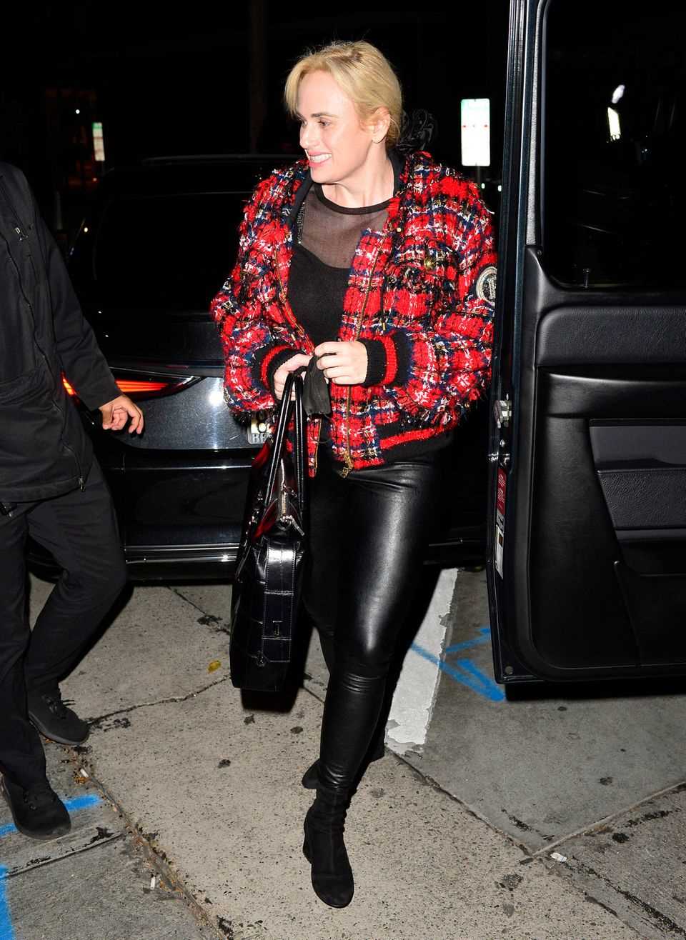 Look ticker: Rebel Wilson in a red and black bomber jacket and leather leggings