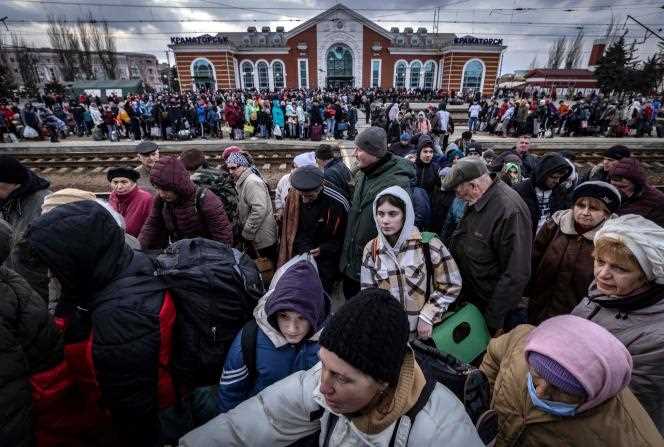 Families walk on a platform to board a train at Kramatorsk Central Station in the east of the country as they flee the city on April 5, 2022.