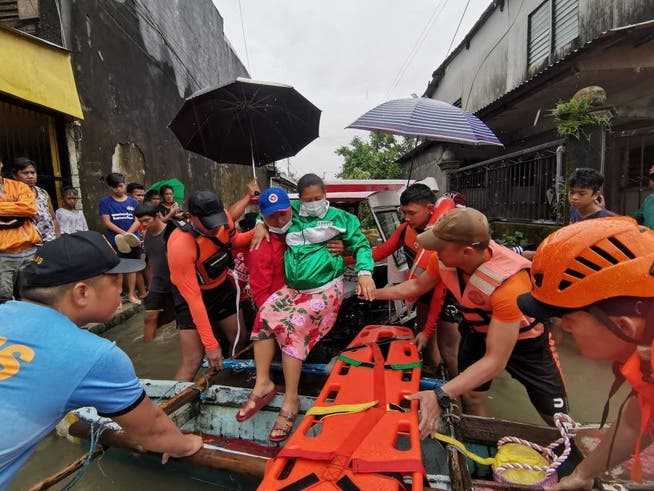 Rescuers help a woman in Leyte province.