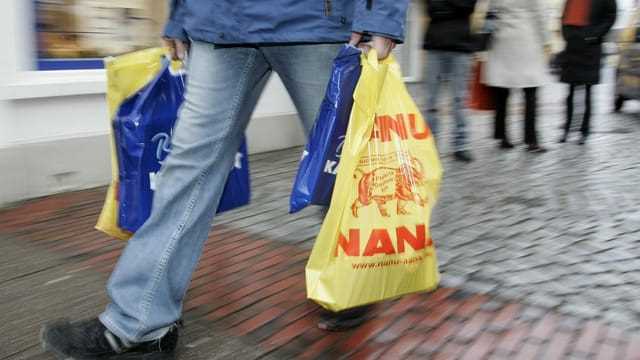 Ein Mann trägt zwei Einkaufstaschen