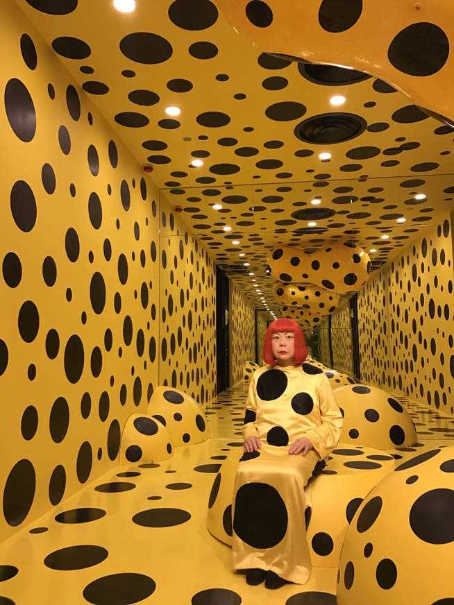 Wax figure of the Japanese artist Yayoi Kusama in an installation with her famous polka dots at Madame Tussauds in Hong Kong.