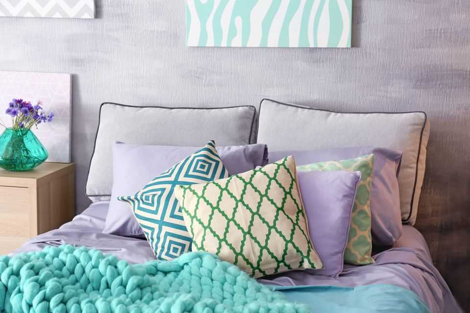 Make the bedroom more comfortable: bed with purple and turquoise blankets and pillows