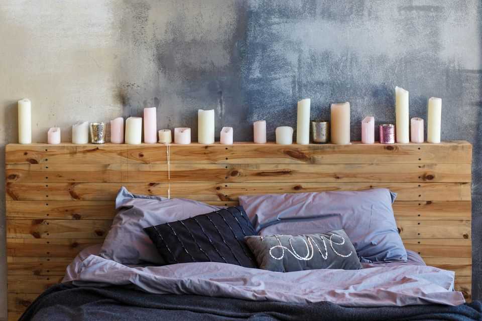 Make the bedroom cozier: wooden shelf with candles at the head of the bed