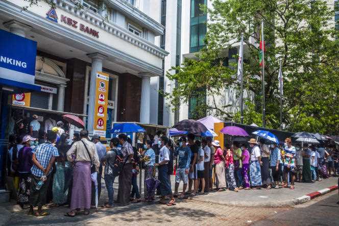 People wait to withdraw money from a bank in Yangon, Myanmar, March 22, 2021.