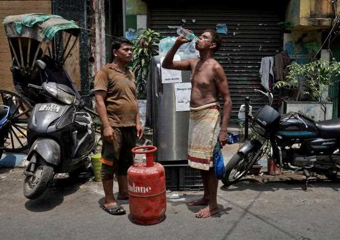A resident distributes free cold water to passers-by during the heat wave in Kolkata, India, April 26, 2022.