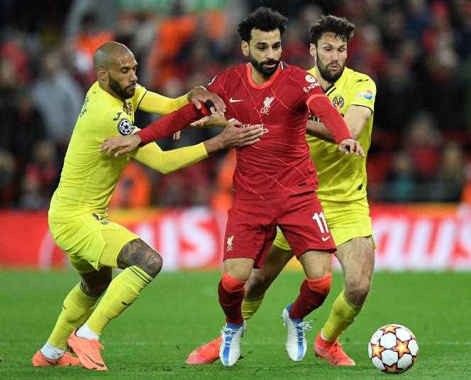 Liverpool midfielder Egypt's Mohamed Salah faces Villarreal midfielders Frenchman Etienne Capoue (left) and Spaniard Manuel Trigueros (right) in the Champions League semi-final first leg at Anfield , in Liverpool (United Kingdom), on April 27, 2022.