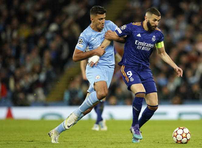 Manchester City's Rodrigo holds off Real Madrid's Karim Benzema in the Champions League semi-final at the Etihad Stadium, Manchester, England on April 26, 2022.