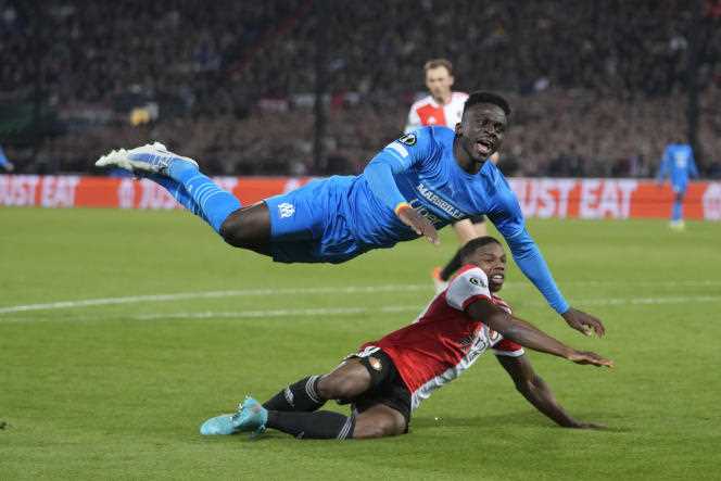 Marseille striker Bamba Dieng (blue jersey) wrestles with Feyenoord player Tyrell Malacia, in Rotterdam (Netherlands), April 28, 2022. 