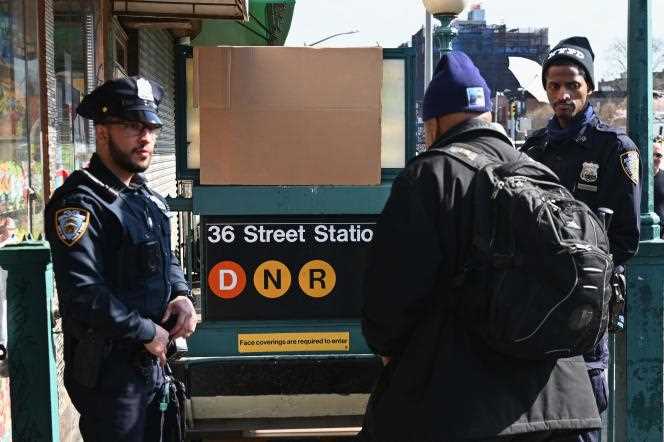 Police stand at the entrance to the 36th Street station April 13 in Brooklyn after a gunman injured twenty-three, including ten by gunfire, the day before.
