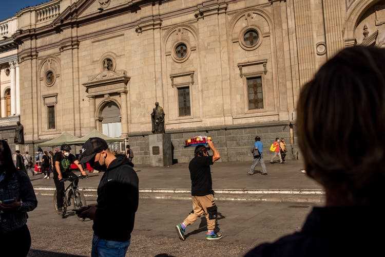 Verkäufer aus dem informellen Sektor halten vor der Kathedrale im Stadtzentrum von Santiago ihre Ware feil.