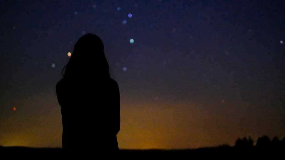 Silhouette einer Person vor Sternenhimmel