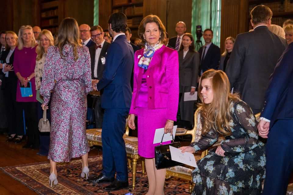 While the audience is waiting for Queen Silvia to take a seat, Princess Beatrice just sits down.