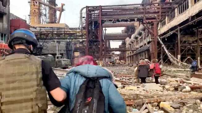 Azov regiment fighters escort civilians out of the besieged Mariupol Steelworks on Sunday.