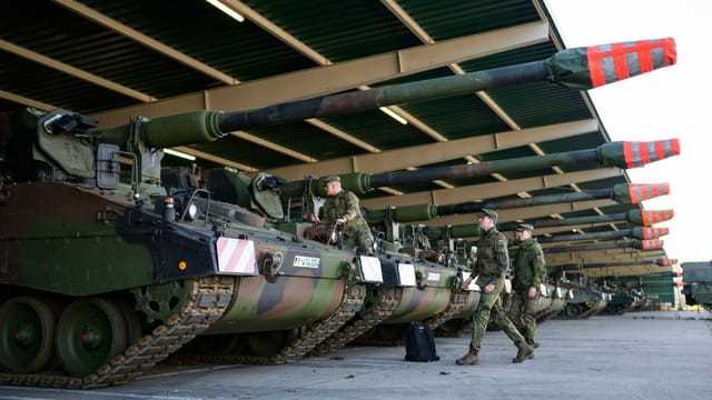 Panzerhaubitzen 2000 (PzH 2000) der Bundeswehr stehen in einer offenen Fahrzeughalle.