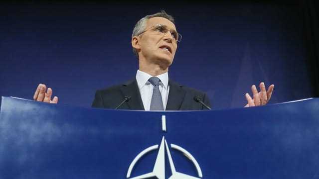 Mann vor Nato-Logo