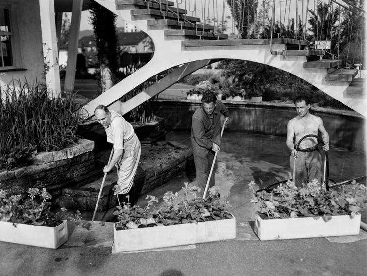 May 1952: Three men clean the basin of the pond below the pavilion in the Letzigraben outdoor pool.