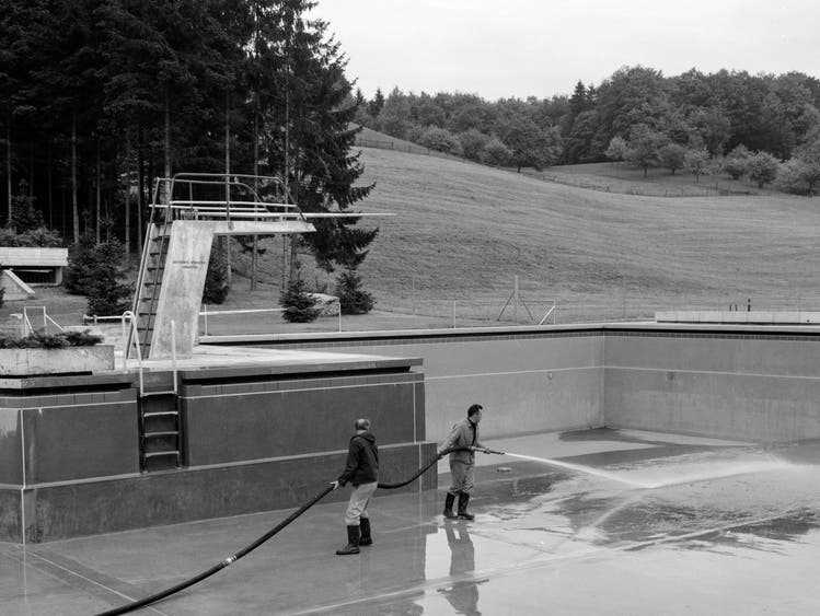 May 12, 1968: Two men clean the pool at the 