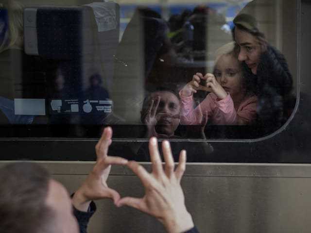 Ukrainian Nicolai says goodbye to his daughter and wife who are on a train bound for Poland on April 15, 2022