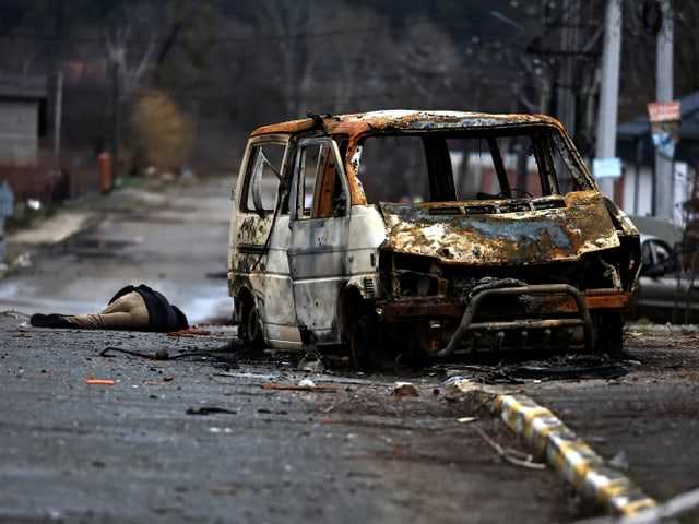 The body lies next to a burned-out car in Bucha near Kyiv