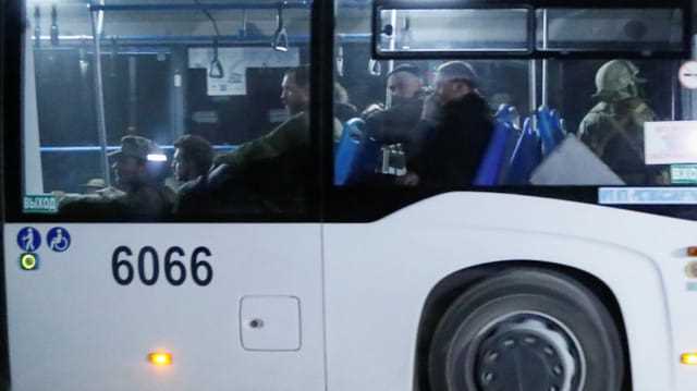 Ein Bus, der Angehörige der ukrainischen Streitkräfte aus dem belagerten Stahlwerk Asowstal transportiert, fährt unter Eskorte des prorussischen Militärs davon (16. Mai 2022).