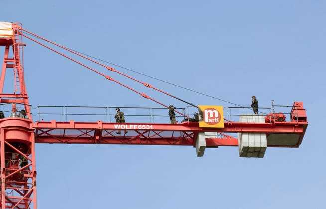 Police officers have been trying for over half a day to get in touch with the unknown man on the crane.