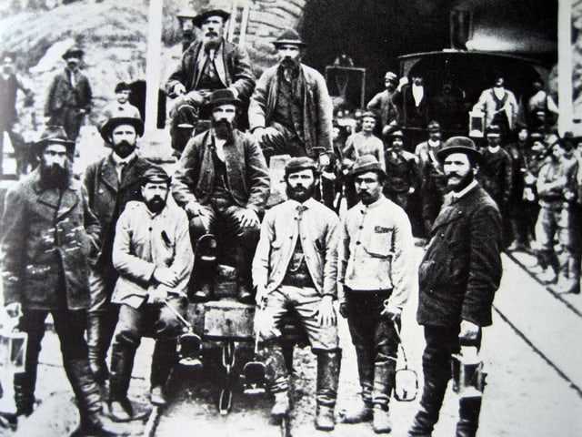 Construction workers pose in Airolo in front of the tunnel