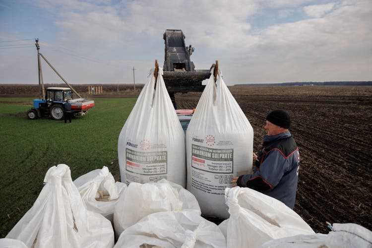 A farmer brings Ukrainian fertilizer to the field.  His village was recently bombed by the Russians.