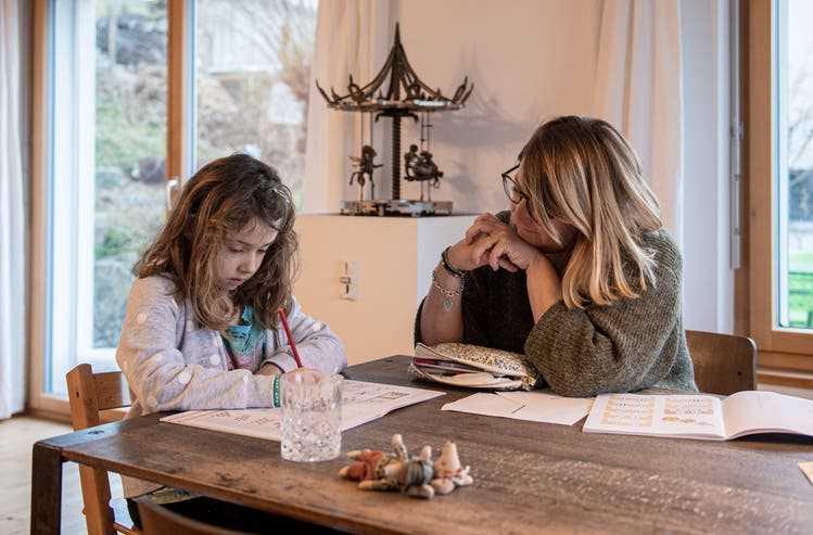 Die sechsjährige Ronja beim Zahlen-Schreiben am Esszimmertisch in Oberlunkhofen. Véronique Reich, die Mutter, die gleichzeitig Ronjas «Lehrerin» ist, schaut zu und hilft bei Bedarf.