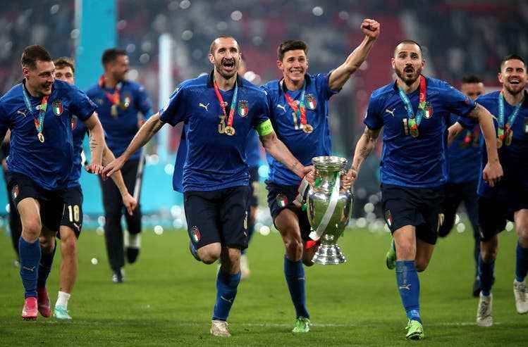 Giorgio Chiellini (2nd from left) and his long-term centre-back partner Leonardo Bonucci carry the trophy for Italy's European Championship win last summer.