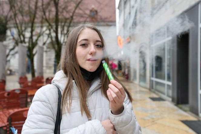 A young woman smokes a 