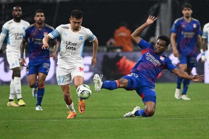 Turkish striker from Marseille Cengiz Under (white jersey) is tackled by Brazilian midfielder from Lyon, Thiago Mendes, at the Vélodrome stadium in Marseille, during the 35th day of Ligue 1, May 1, 2022.