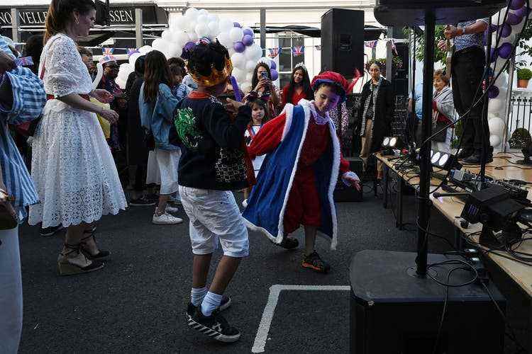 A rock band plays at the street party on Abingdon Road in London, and children dance in front of the stage.