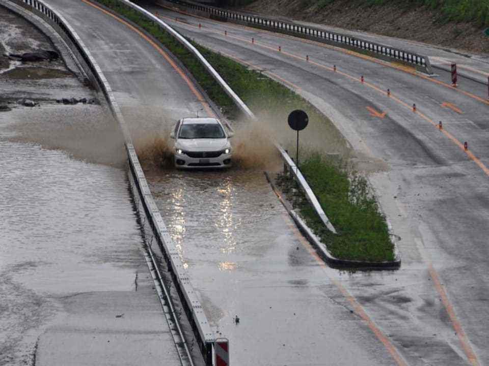 Flooded highway with a lot of water on the roadway and a car