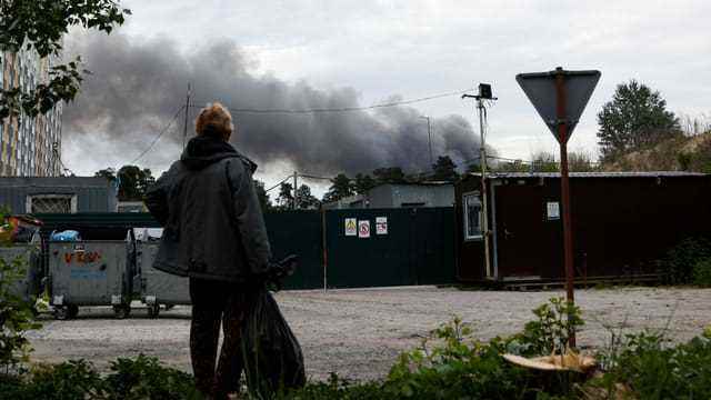 Ein Mann betrachtet den Rauch nach den Explosionen, die während der russischen Angriffe auf Kiew zu hören waren.