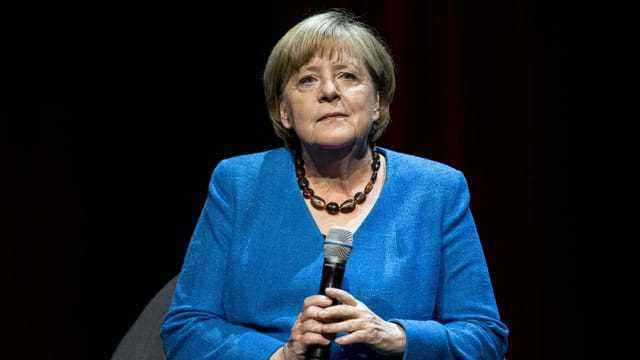 Merkel mit Mikrofon.