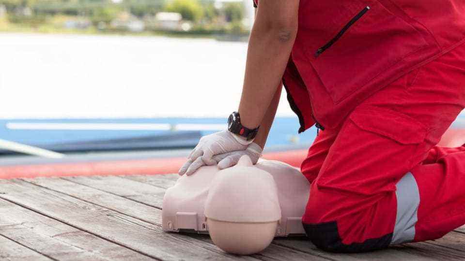 A man practices CPR on a dummy.
