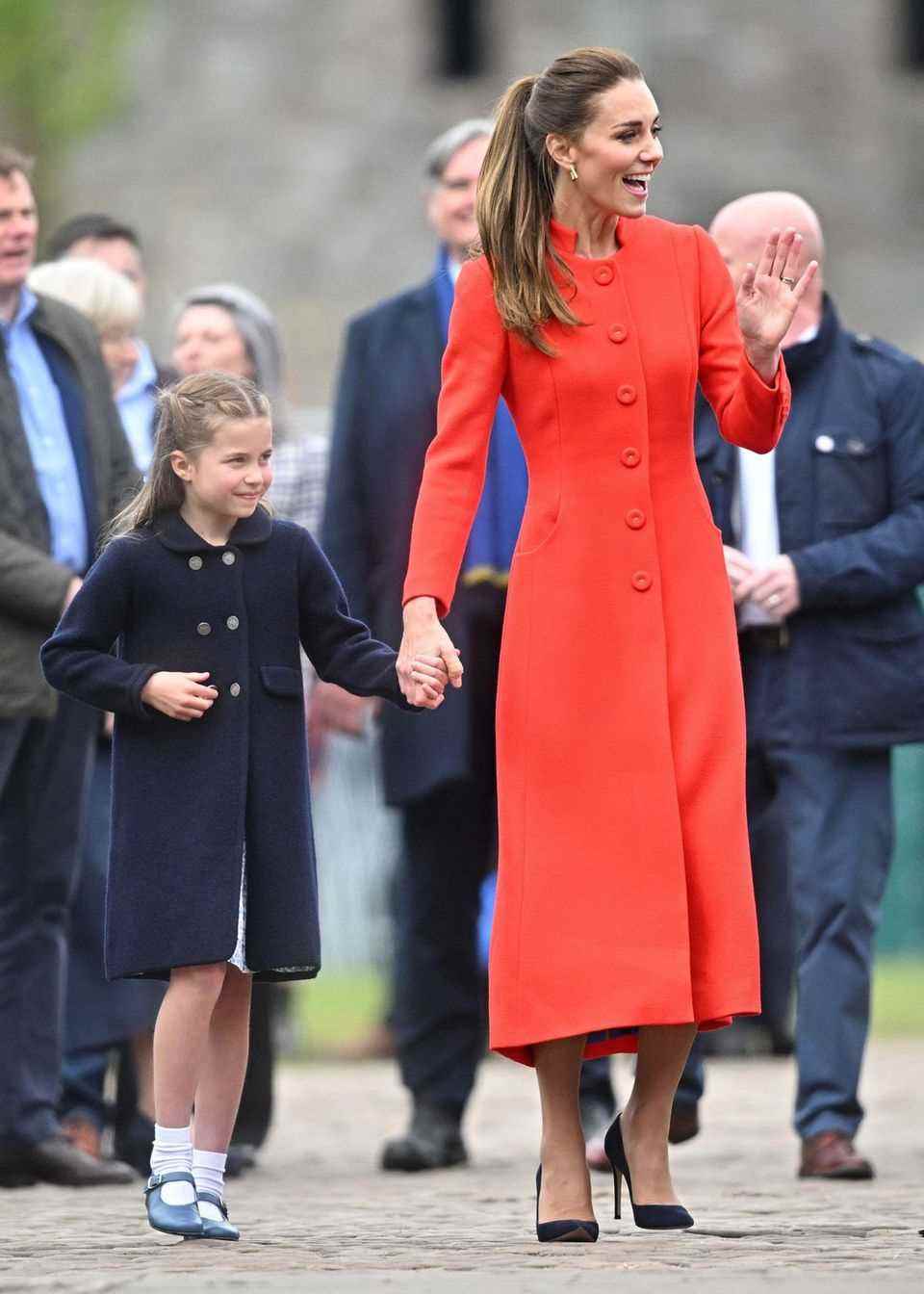 Celebrations of Queen Elizabeth's 70th jubilee will begin next week.  Of course, Duchess Catherine should not be missing.  At the concert in Wales she appears in a red and orange coat dress.  Unlike the days before, she wears her hair in a voluminous ponytail.  Her black pumps form a modern contrast to the bright dress.  10 points for outfit number 3!