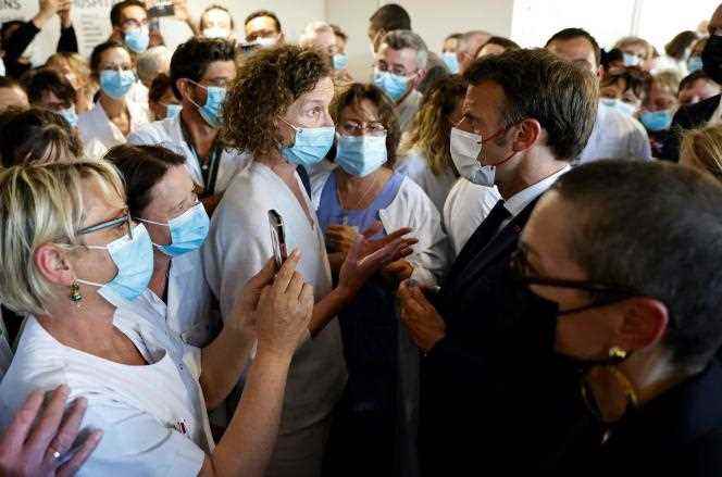 Emmanuel Macron speaks with a health worker from the Cotentin public hospital center, during a visit dedicated to access to urgent and unscheduled care, in Cherbourg (Manche), May 31, 2022. 
