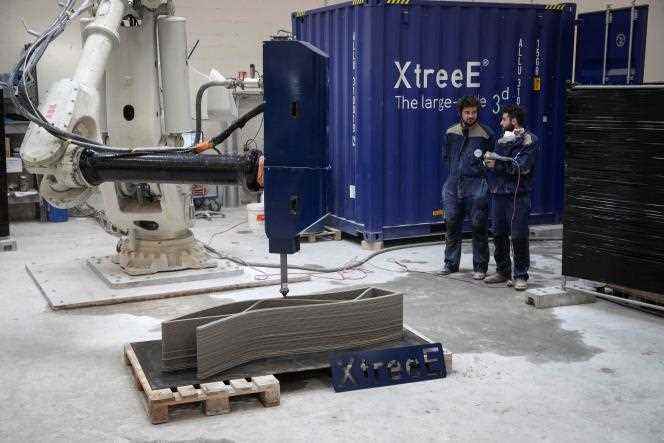 Employees of the start-up XtreeE observe a robotic arm printing a concrete wall, in Rungis (Val-de-Marne), in 2019.