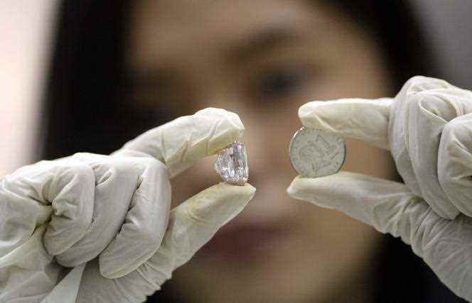An official shows a pink diamond that belonged to Imelda Marcos, seized by the Philippine government, at the headquarters of the Central Bank in Manila, November 27, 2015.