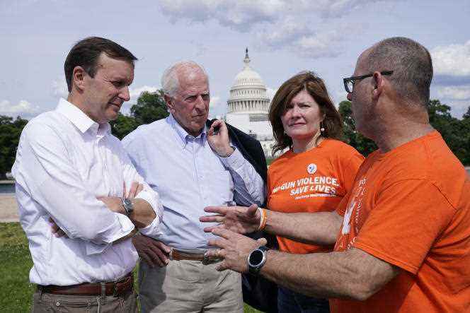Democratic Sen. Chris Murphy (L), and Republican Rep. Mike Thompson (2nd L) talk with activists for greater gun control, during a rally in Washington, June 10, 2022. 
