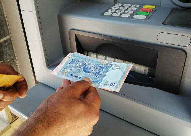 A man withdraws cash from an ATM in Tunis in May 2021.